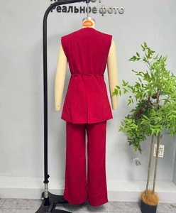 Rear view of red two-piece sleeveless vest set with waist belt and wide leg trousers