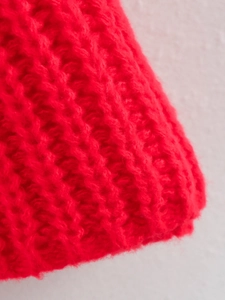 Dettaglio ravvicinato di maglia spessa rossa con trama morbida e fibre pelose