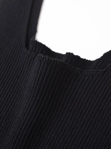 Détail rapproché du tissu en maille côtelée noire montrant la texture et l'élasticité