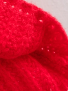 Macro dettaglio della trama in maglia rossa vibrante e dei punti di cucitura