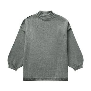 Detailed knit texture and ribbed neckline of a sage green mock neck oversized sweater