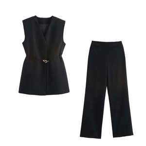 Detail of black two-piece vest and trousers set with gold buckle belt and split design