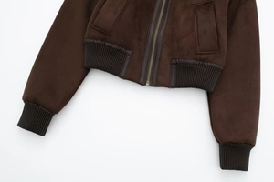 Detail of a dark brown bomber jacket with metal zipper and ribbed knitted hem texture