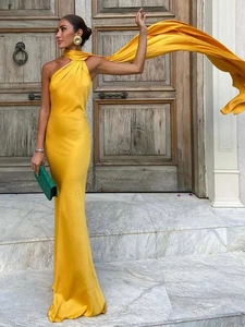 Detail of elegant yellow satin halter maxi dress with long flowing neck ties and open back