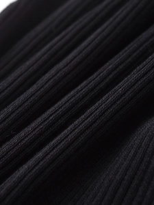 Gros plan sur un tissu en maille côtelée noire montrant la texture et les nervures