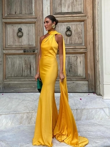 Detail view of yellow satin halter gown with long flowing ties and fishtail hem