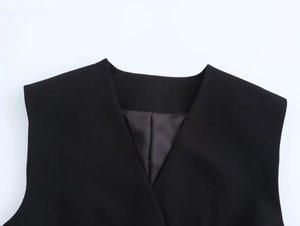 Detailed close-up of V-neckline with smooth satin lining on a black sleeveless waistcoat