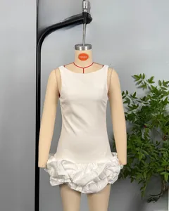 Detail of white sleeveless mini dress featuring a pleated bubble hem and satin finish