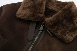 Detail of dark brown faux suede jacket featuring warm shearling collar and bronze metal zipper