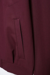 Detailed view of deep burgundy jacket side pocket with high-quality stitching and fabric