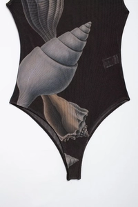 Detailed macro view of black mesh bodysuit fabric with realistic seashell and conch prints