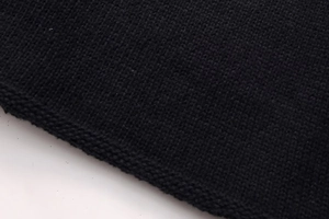 Close-up detail of the fine knit texture and neat stitching on a black sweater