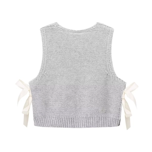 Detail view of grey chunky knit vest featuring elegant side white ribbon bow accents