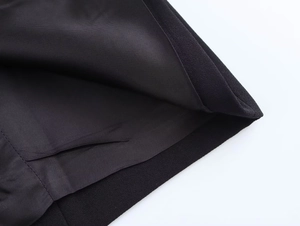 Detail of black woven suit fabric with smooth silk lining and precise hem stitching