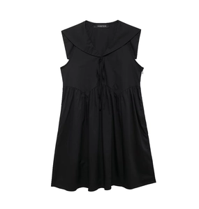 Close-up of black sleeveless dress with preppy collar, bow tie and pleated waist detail