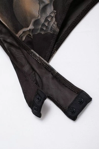 Macro shot of skull print mesh bodysuit with functional snap button closure detail