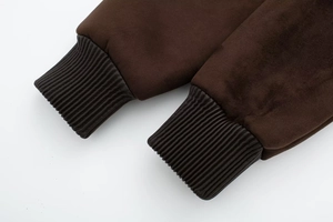 Detailed macro view of dark brown faux suede fabric and ribbed knit cuffs on jacket
