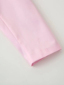 Detailed macro view of the smooth light pink satin fabric texture on the cuff