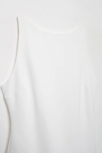Close-up of white sleeveless dress showing fine fabric texture and clean side stitching