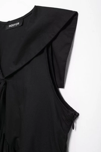 Detail view of the black short dress featuring a shawl collar and hidden side zipper