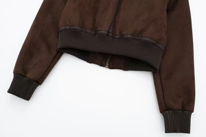 Detail of dark brown suede jacket with ribbed hem, PU piping and bronze metal zipper