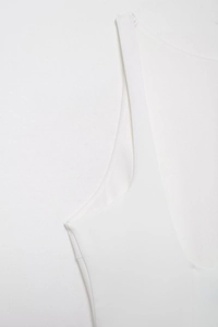 Close-up of white sleeveless dress showing high-quality stitching and elastic fabric detail