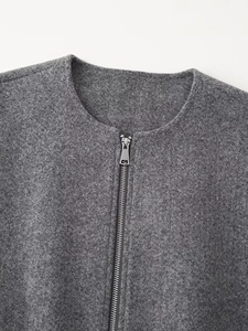 Close-up of the silver metal zipper and dark gray wool blend texture on the jacket neck
