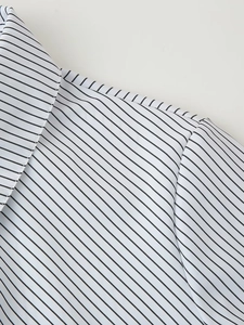 Close-up of the collar and shoulder seams showing fine stripe alignment and fabric texture