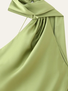 Detail of light green satin dress featuring elegant draped neck and pleated texture