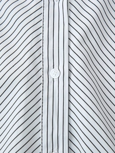 Detailed close-up of a white striped shirt showing the button placket and fine texture