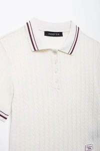 Close-up of cable knit texture on white polo shirt with burgundy stripes and buttons