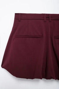 Detail of burgundy high-waist mini skirt with welt pocket and bubble hem fabric texture
