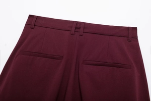 Detail of burgundy suit skirt back featuring belt loops and pockets on woven fabric