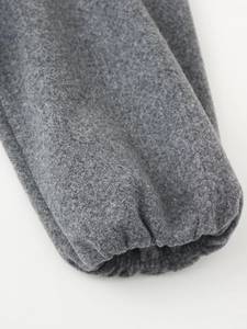 Detailed close-up of the grey fleece fabric and elastic ribbed cuff on the sleeve