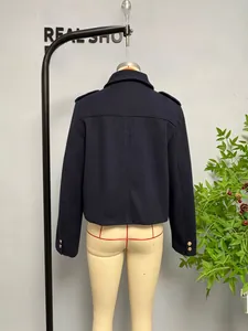 Detail view of the back of a navy blue cropped jacket with shoulder tabs and golden buttons