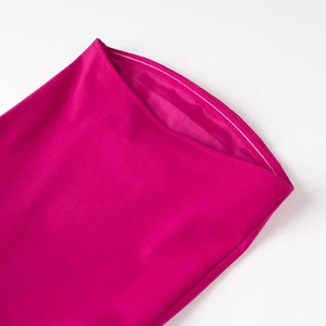 Détail macro des coutures en satin rose rouge et de la texture lisse de cette robe