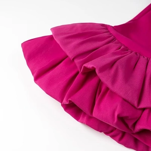Détail des couches de volants magenta et de la texture du tissu tissé haute densité