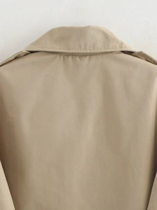 Detail view of khaki trench coat collar and twill fabric texture with fine stitching