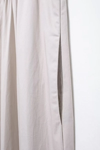Gros plan de la poche latérale sur une robe midi sans manches beige minimaliste