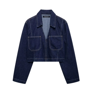 Close-up of dark blue cropped denim jacket with chest pockets and stitch details