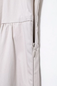 Détail de la fermeture éclair invisible sur une robe midi beige clair en tissu sergé