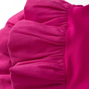 Gros plan sur les volants fuchsia d'une robe d'été légère sans bretelles en mousseline
