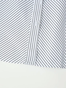 Detailed close-up of striped shirt fabric showing fine stitching and button quality