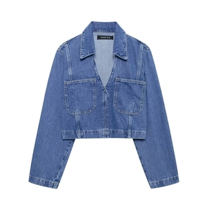 Detail of blue cropped denim shirt featuring long sleeves and large chest pockets