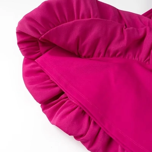 Détail de la robe fuchsia avec volants superposés et texture de tissu plissé élégant