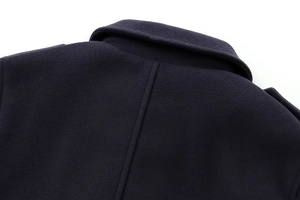 Detailed macro view of the navy blue wool jacket's collar and neat back stitching