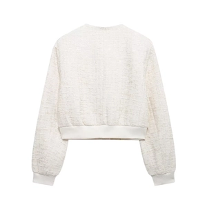 Détail du dos d'une veste en tweed beige montrant la texture tissée et les bords côtelés