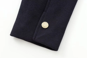 Close-up of navy wool jacket featuring a vintage gold crest button and premium texture