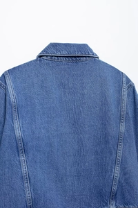 Detailed view of the denim shirt collar and shoulder with contrast stitching