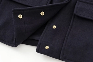 Close-up of navy wool jacket featuring premium texture and gold metal snap buttons